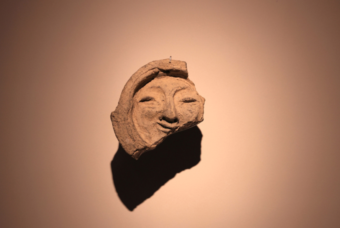 ront view of the “Smile of Silla,” a human-face tile from the Silla period at the National Gyeongju Museum. This timeless design inspired the APEC 2025 Korea emblem, alongside a butterfly symbol of connection and innovation