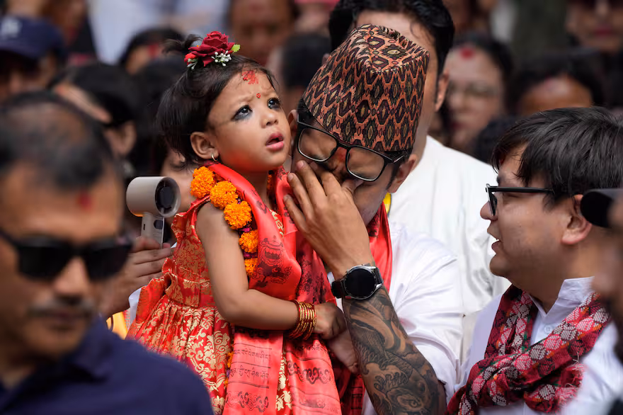 La nueva diosa viviente de Nepal, la Kumari Aryatara Shakya, es llevada en brazos por su padre