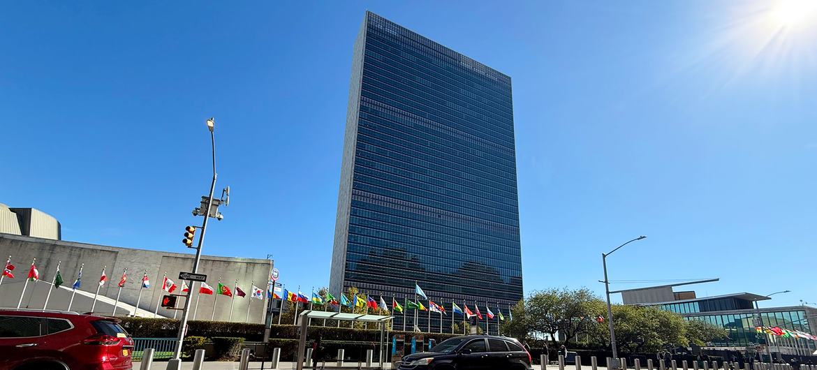 The Secretariat building with flags of Member States in the foreground, at UN Headquarters