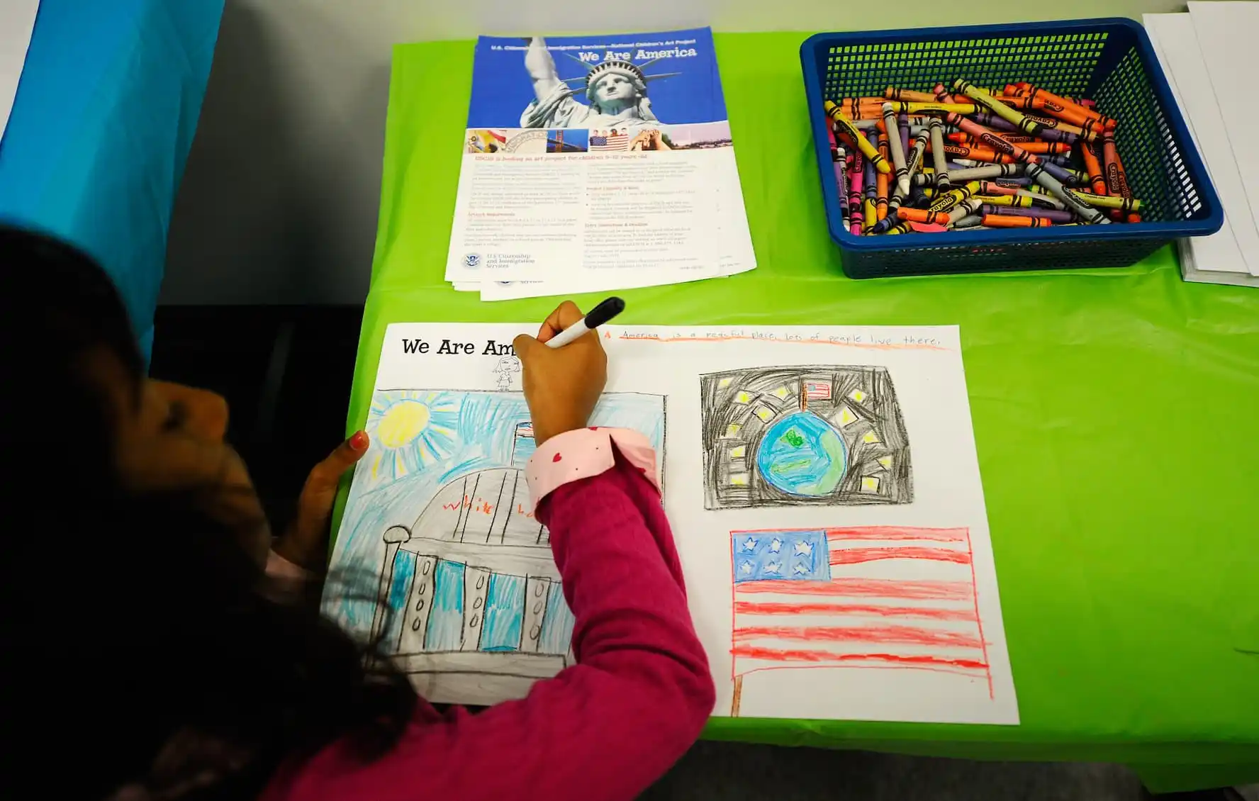 LOS ANGELES, CA - AUGUST 19: Thasuni Bandara, 8, from Sri Lanka, takes part in U.S. Citizenship and Immigration Services commissioned art project for children across the United States before taking the Oath of Allegiance during a citizenship ceremony on August 19, 2010 in Los Angeles, California. During the ceremony 143 people, including 30 area children under the age of 14, received certificates of citizenship. Children were asked to create images depicting their interpretation of the theme, "We Are America."