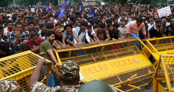 Supporters of the Cockroach Janta party push against a barricade as they attempt to march to India's parliament on Monday.