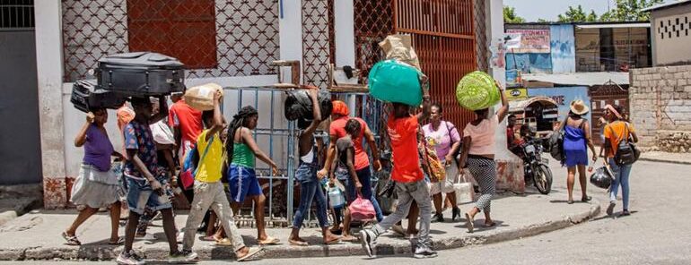 Personas que transportan sus pertenencias sobre la cabeza en Puerto Príncipe, Haití.