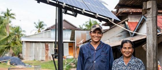 Una pareja en Camboya posa junto a un panel solar recién instalado.