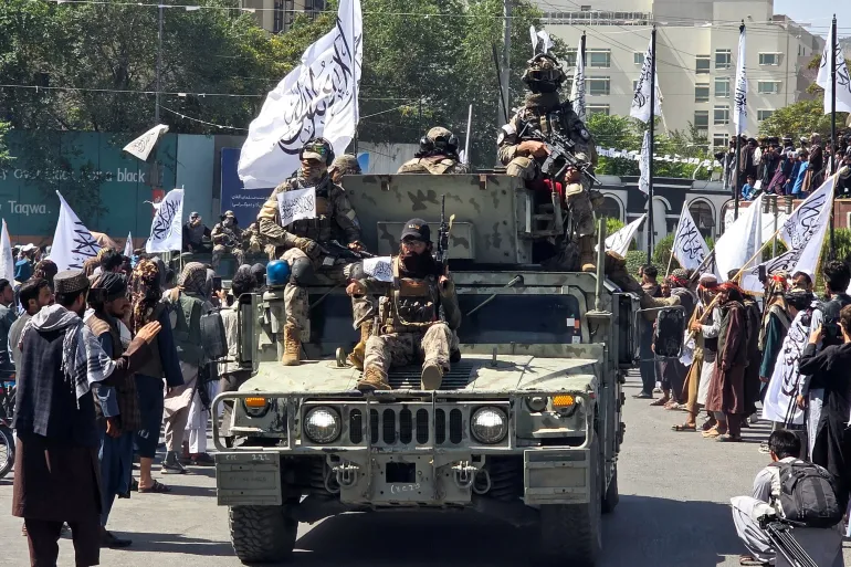 Members of the Taliban attend a rally marking five years in power outside the former US embassy in Kabul, Afghanistan