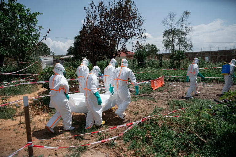 Red Cross volunteers in the Democratic Republic of the Congo carry the body of an Ebola victim from the morgue before loading it into a vehicle for transfer to a cemetery. The measures are part of safe and dignified burial operations aimed at preventing the spread of the virus.